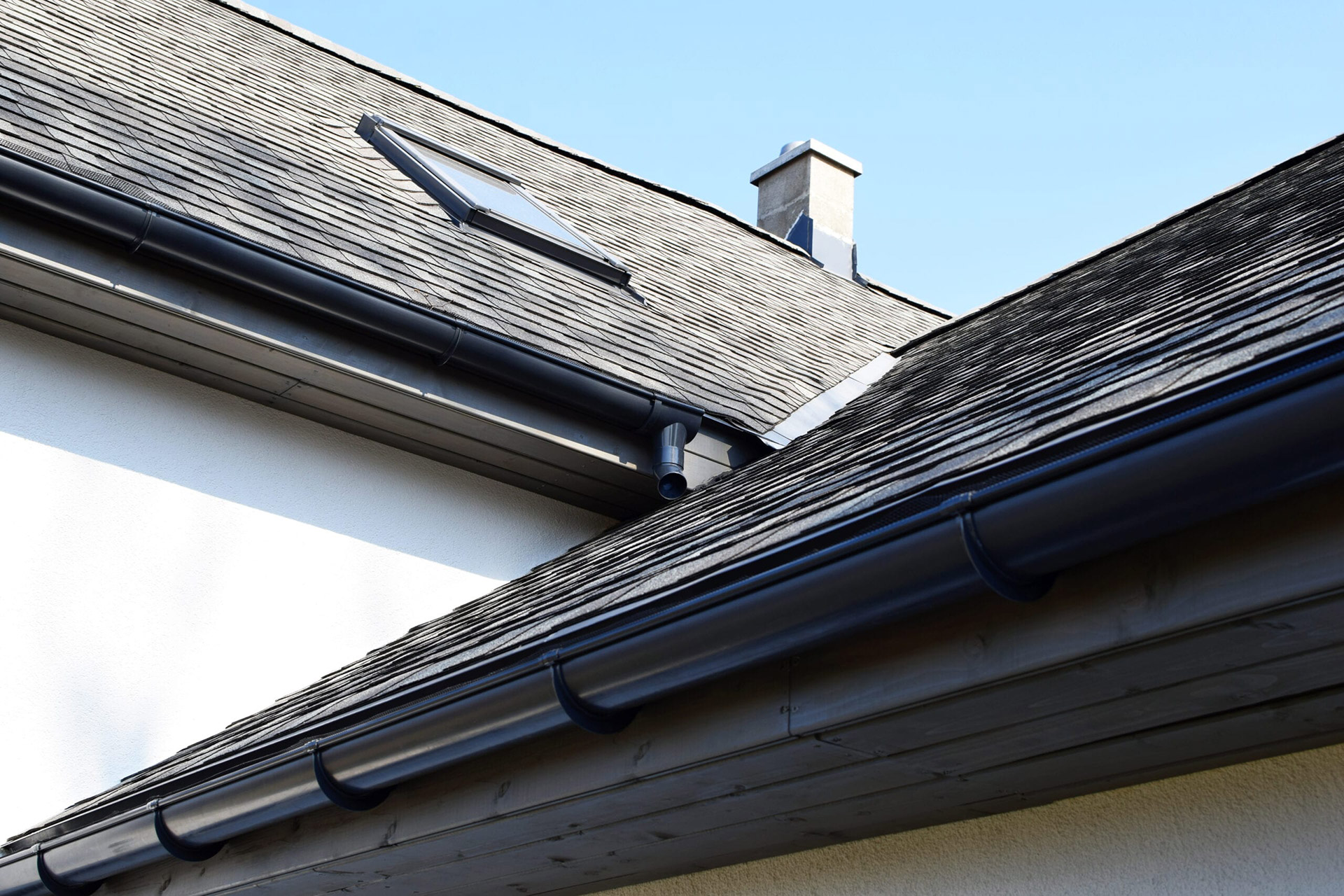 Grey asphalt shingles roof construction gutters